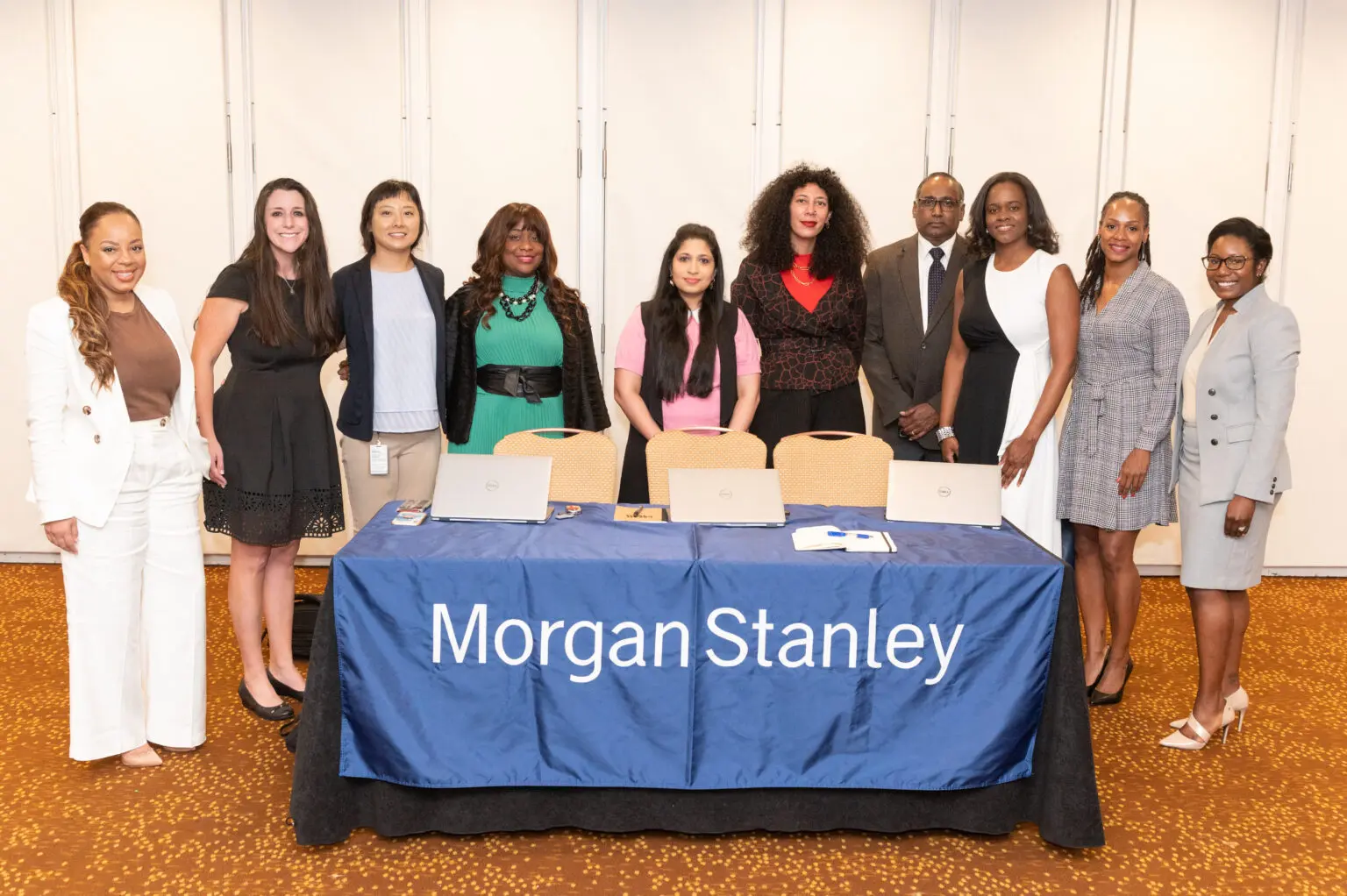 Group standing behind Morgan Stanley table.
