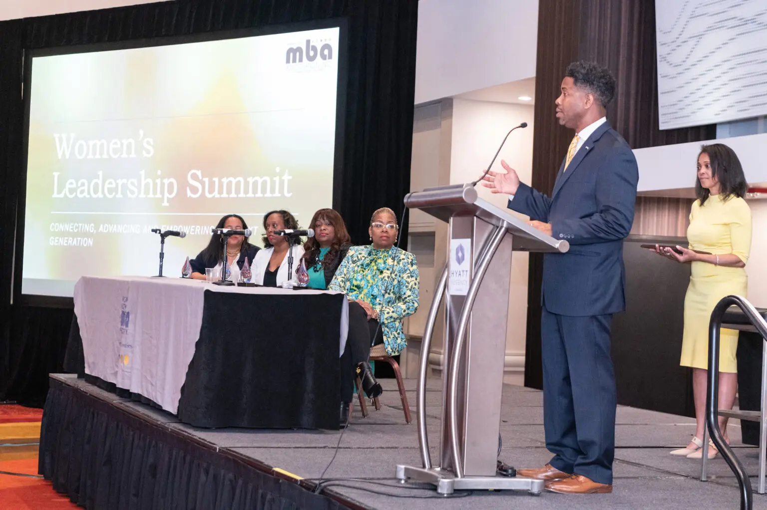 Man speaking at Women's Leadership Summit panel.