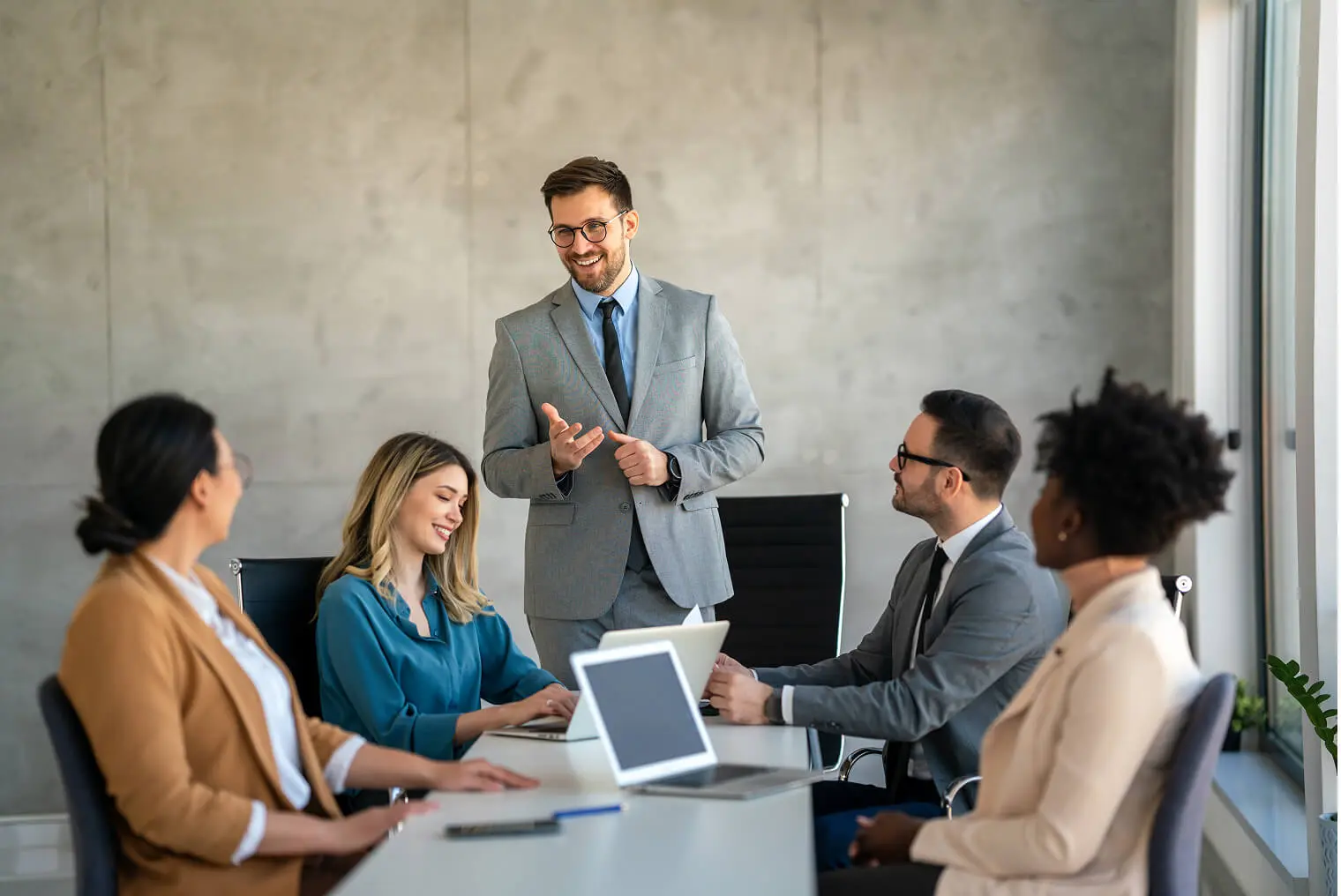 Business meeting with five people discussing.