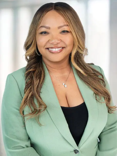 Smiling woman in green blazer.